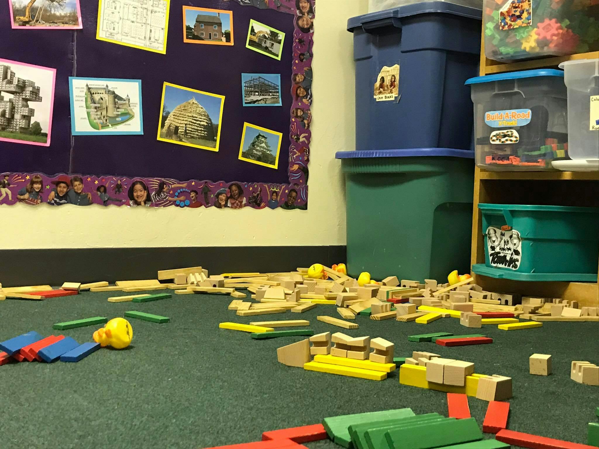 Wooden and colorful building blocks scattered on a green carpet