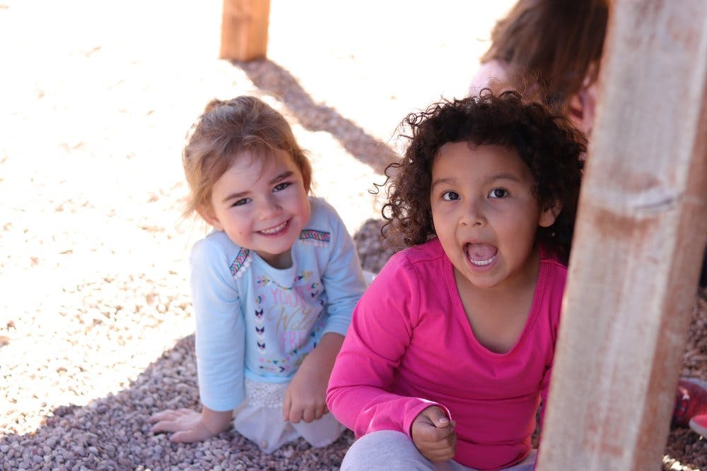 Two children sitting on the ground