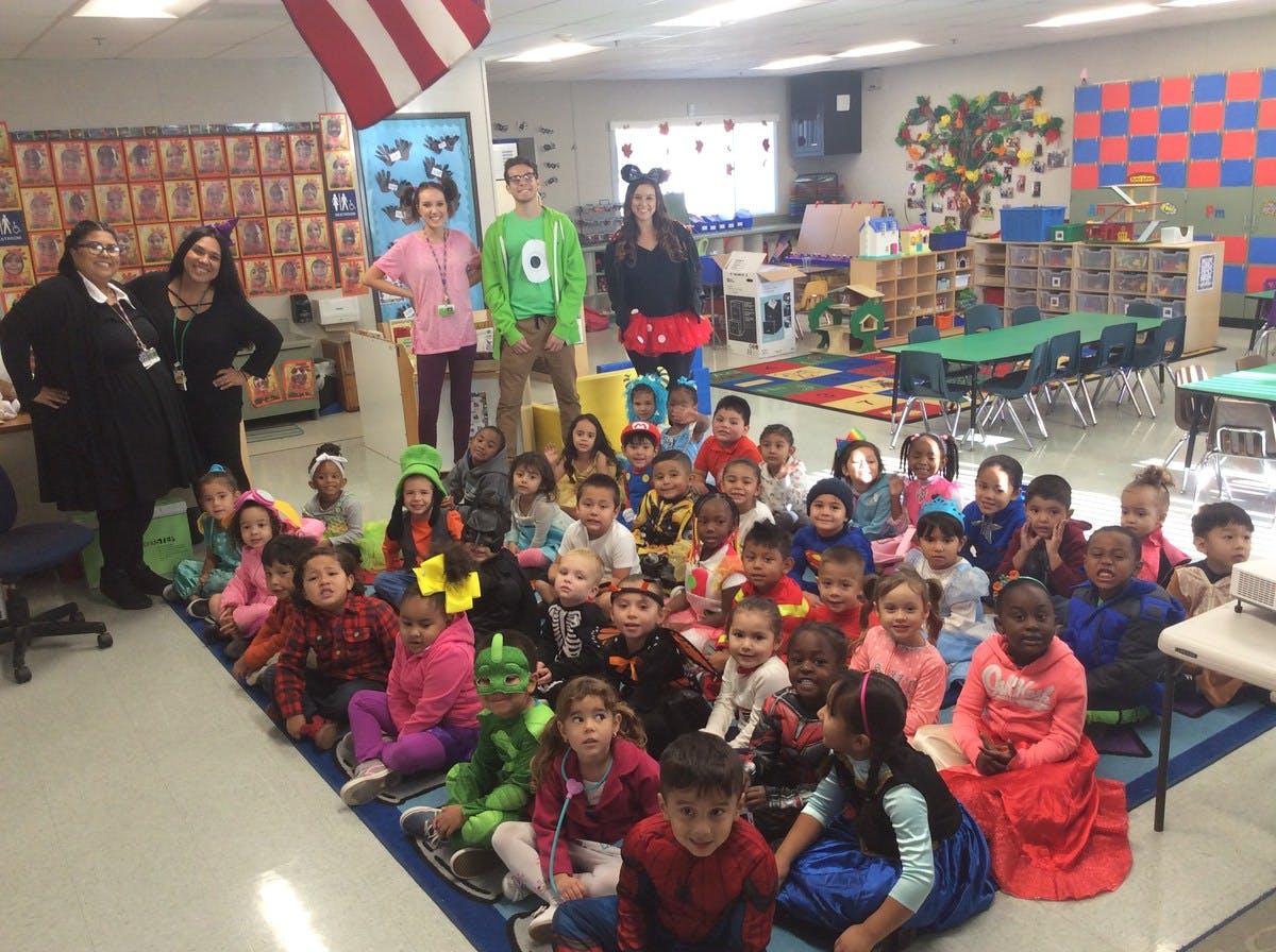 Adults and children in costumes in a classroom