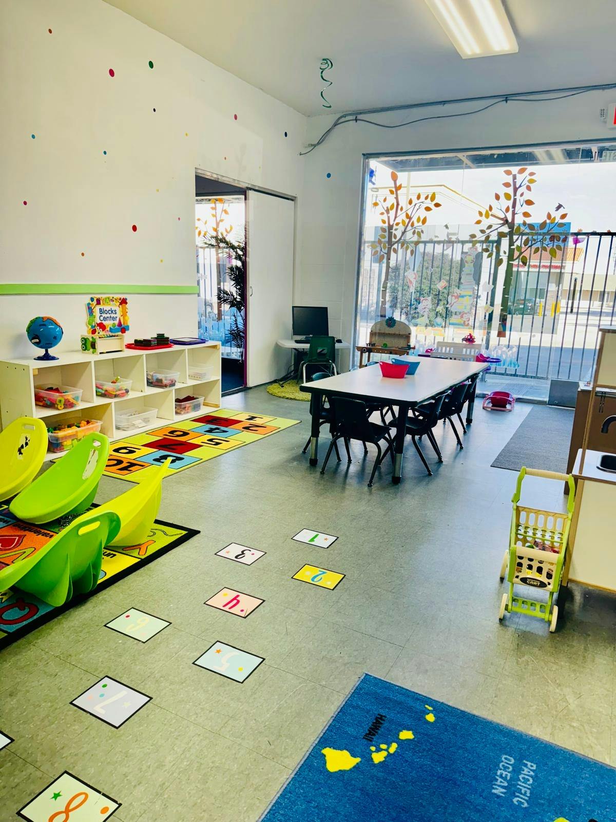 Classroom with tables, chairs, and colorful rugs