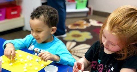 Two children doing an art activity at a table