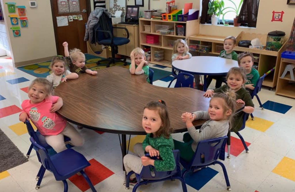 Children sitting at tables in a classroom