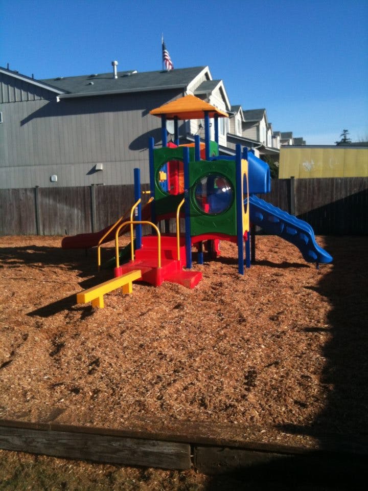 Colorful playground structure with slides and climbing areas on wood chips