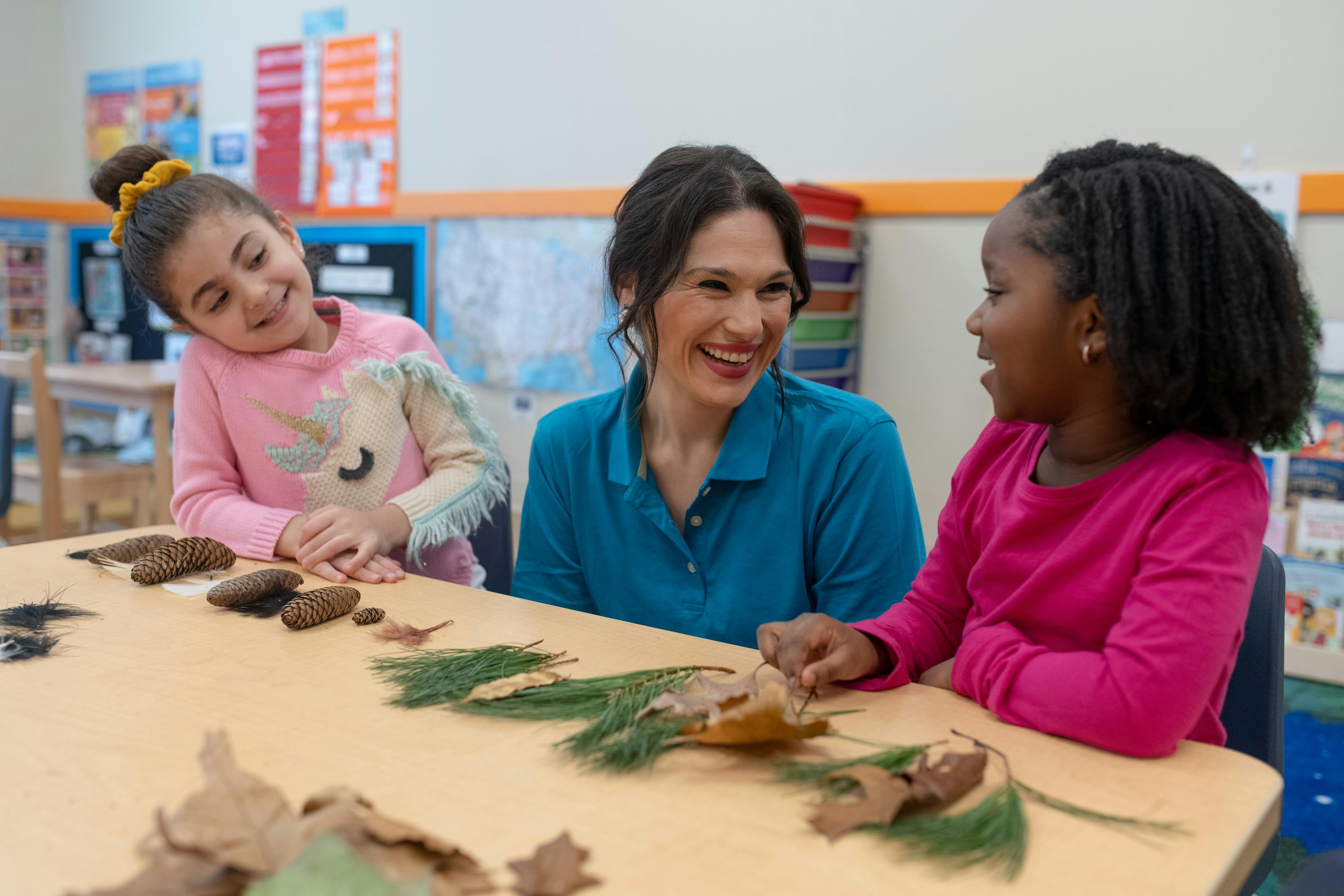 Adult and two children at a table with natural items