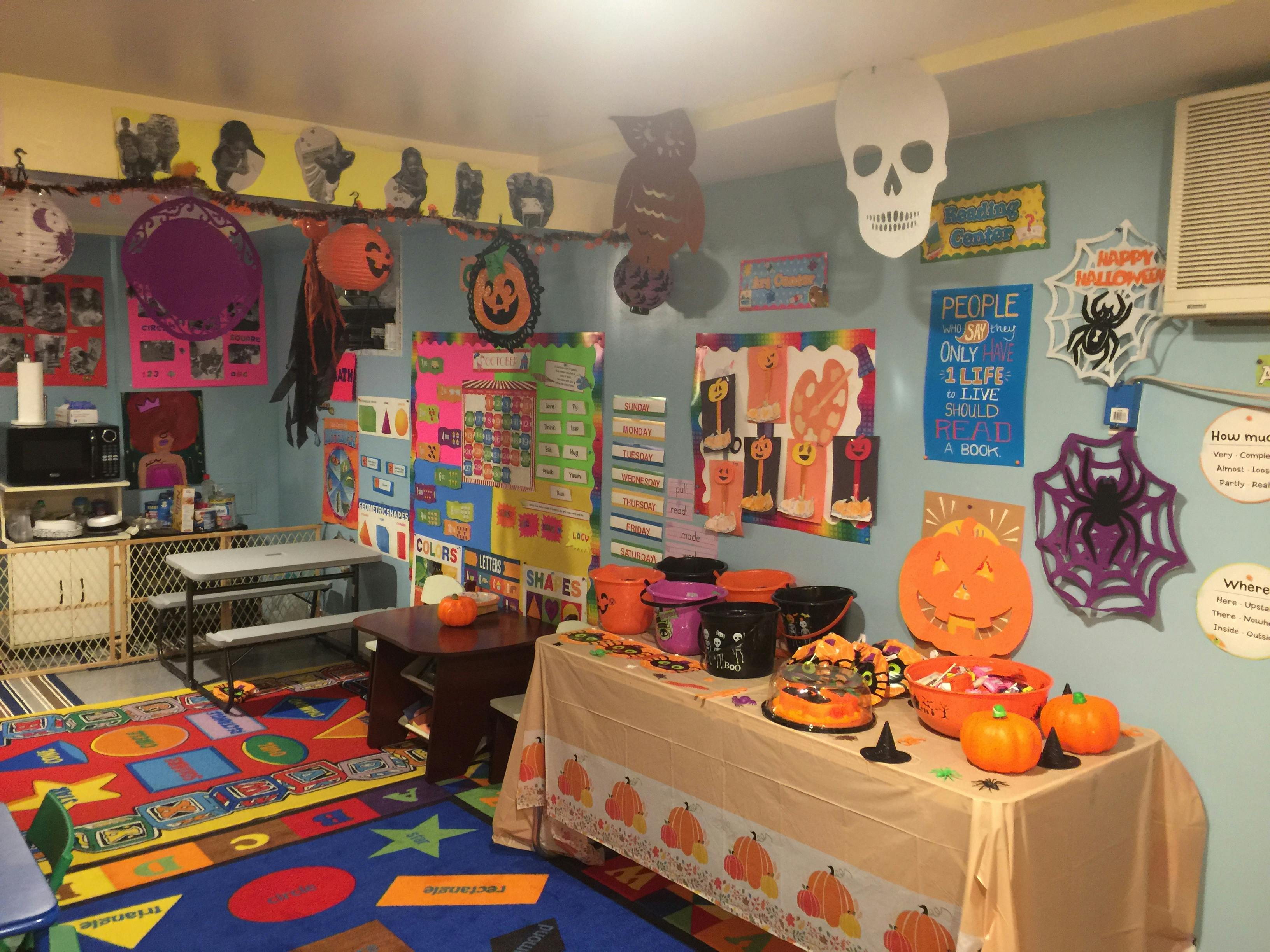 Room decorated for Halloween with a table of treats and a colorful rug