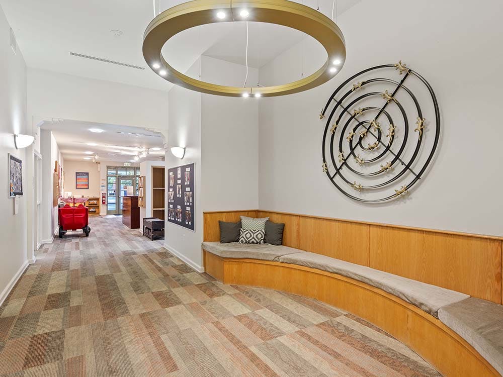 Lobby area with a long curved wooden bench with cushions