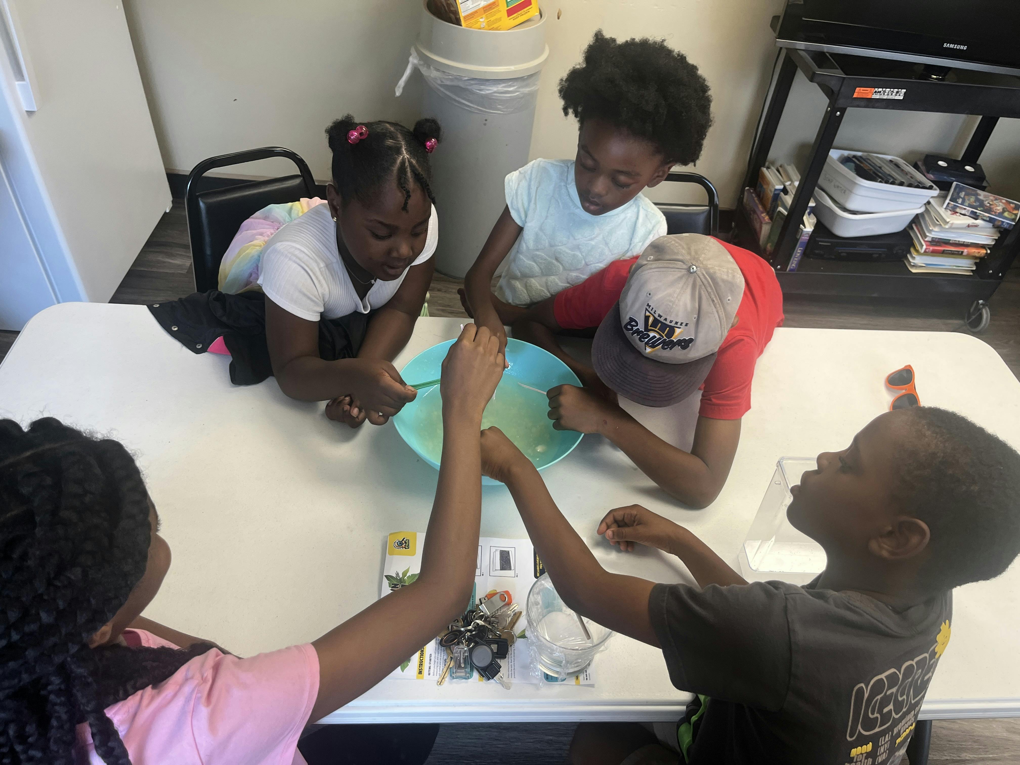 Children gathered around a table with a bowl