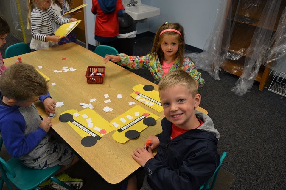 Children making bus crafts at a table