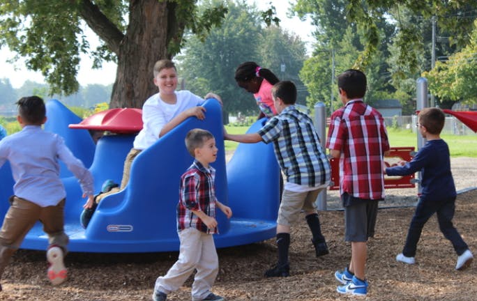 Children playing on a blue merry-go-round