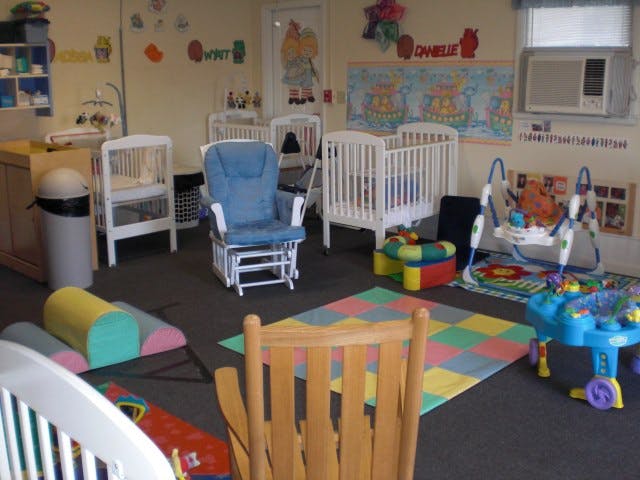 Nursery room with cribs, a rocking chair, and play mats