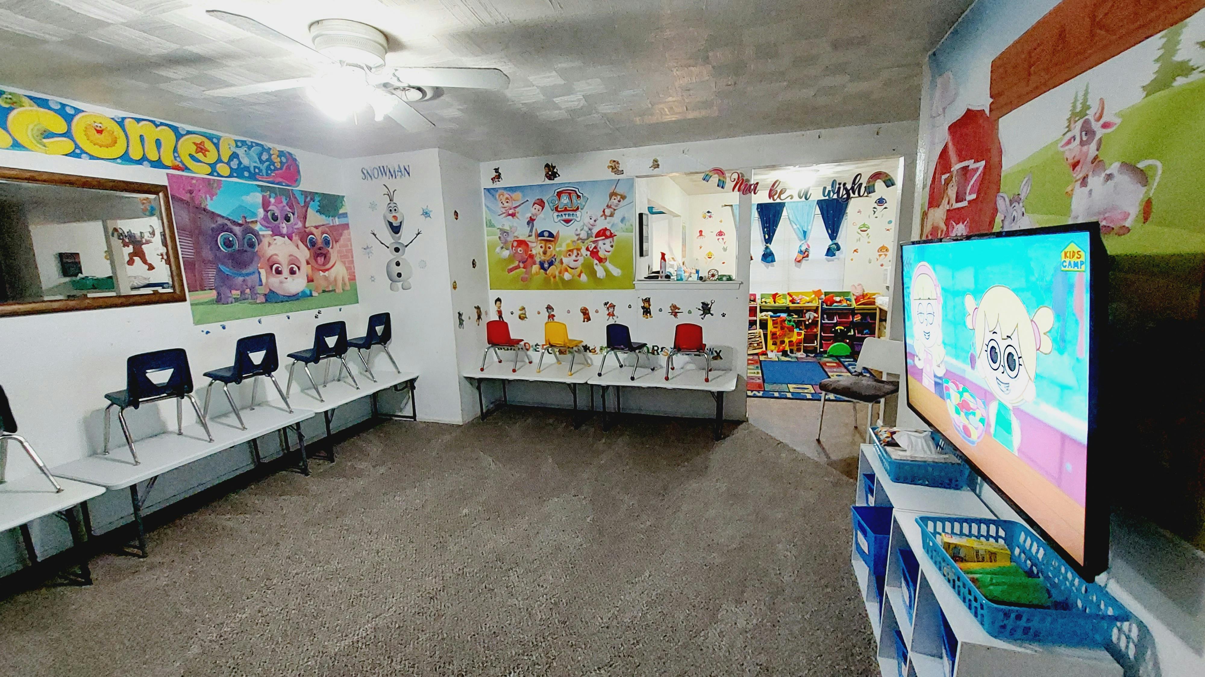 Children's waiting room with small chairs, tables, and a television