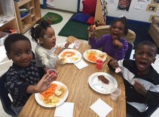 Four children eating at a table
