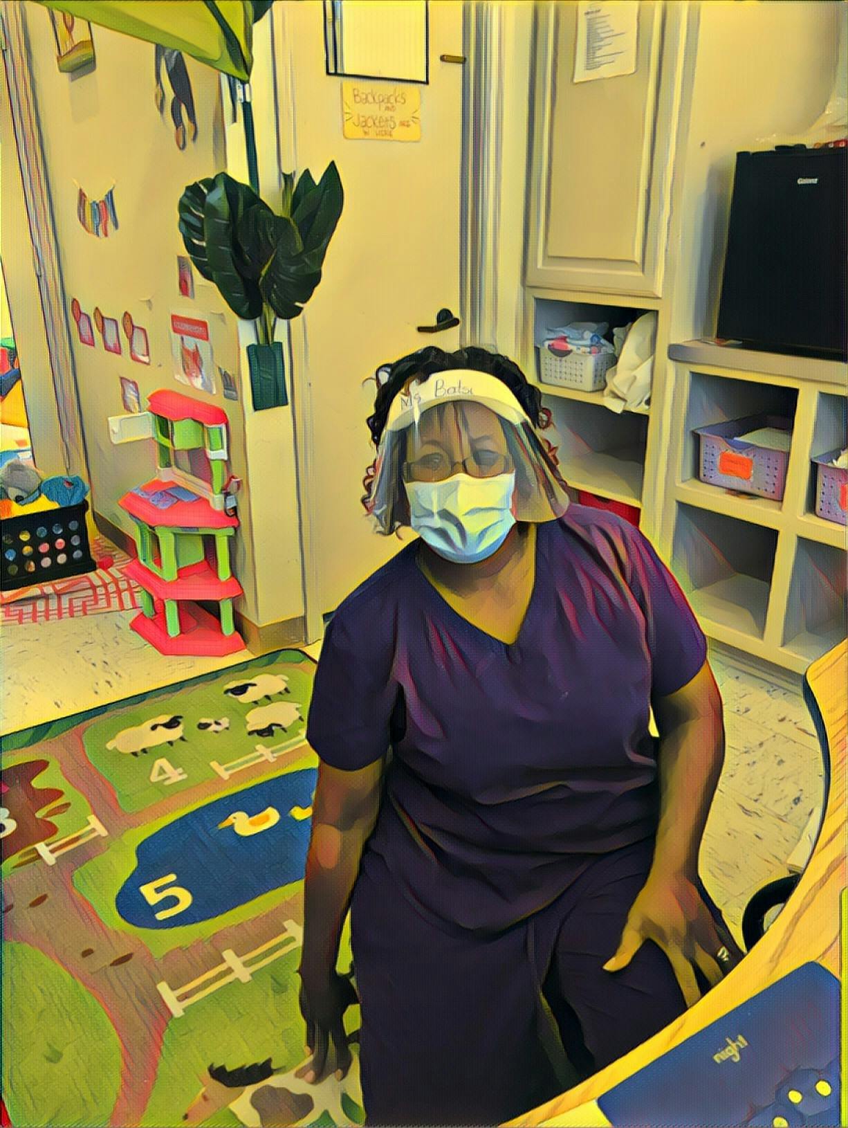 Person wearing a face shield and mask in a classroom