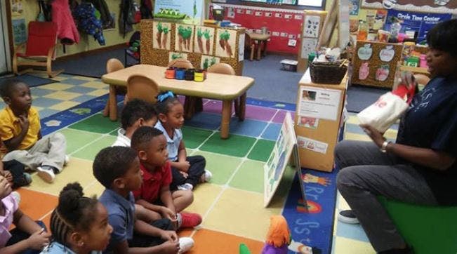 Adult reading to children in a classroom
