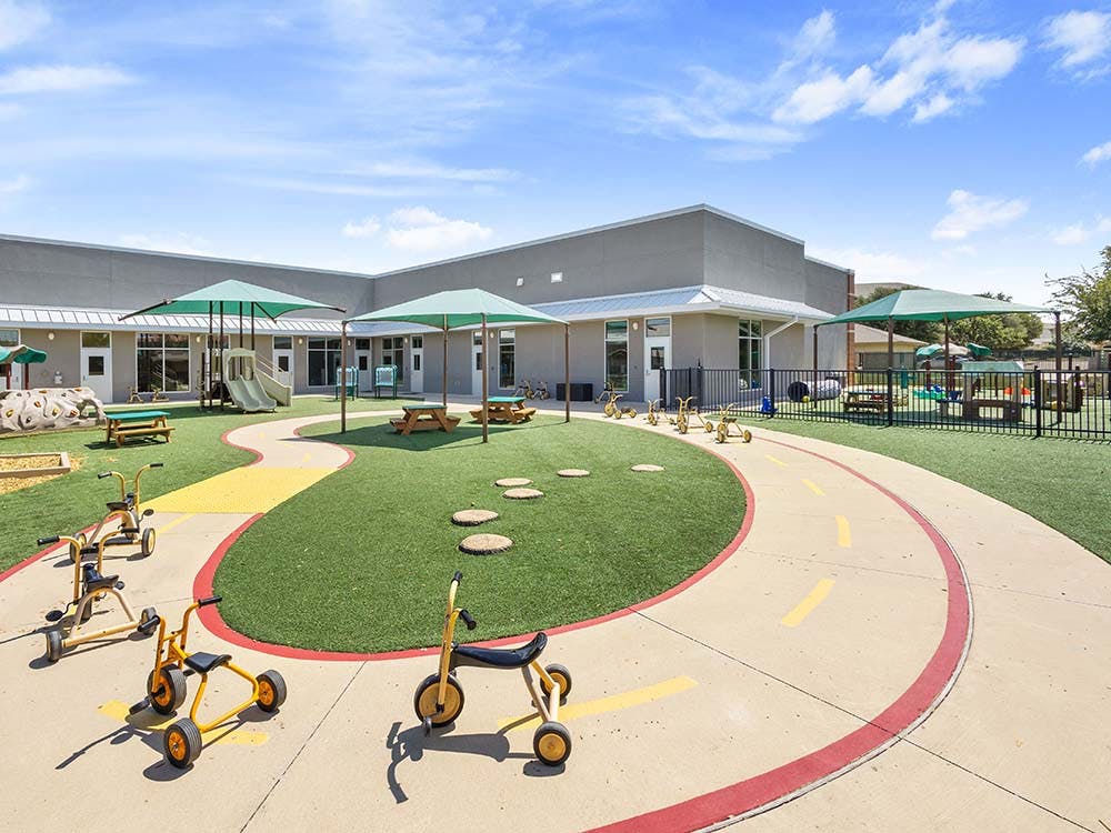 Outdoor children's play area with tricycle track and playground equipment