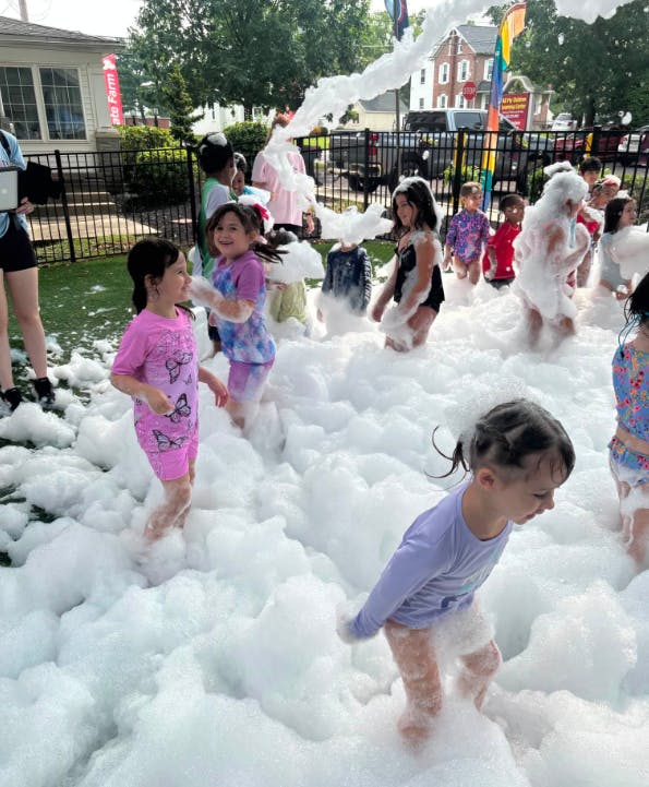Children playing in a foam party outside