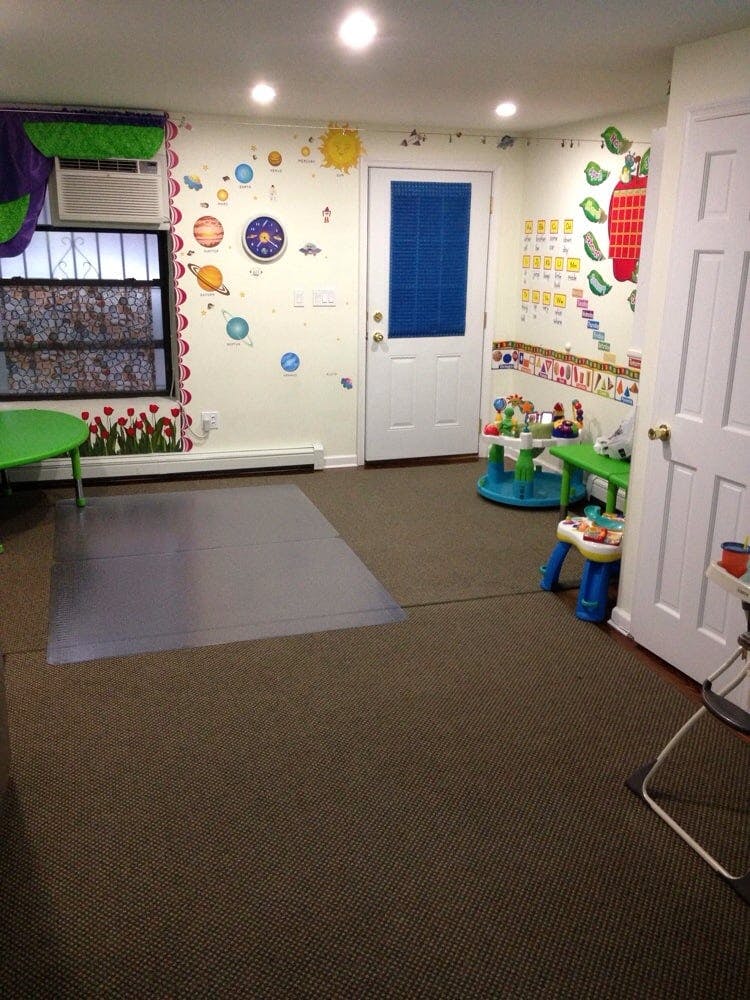 Playroom with colorful wall decals, a window, and child-sized furniture