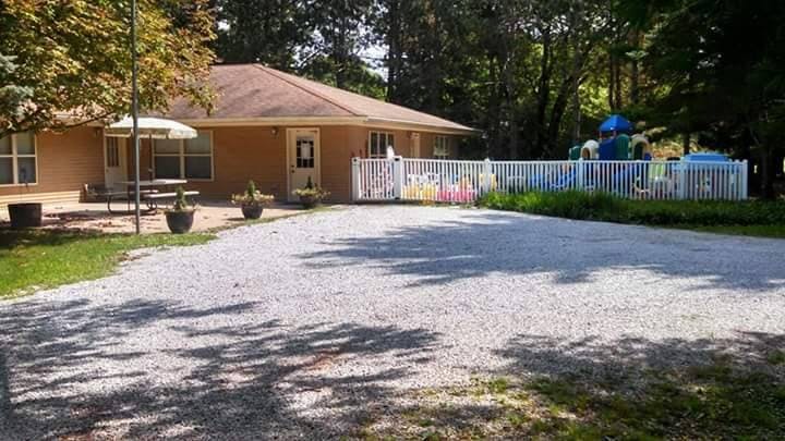 Building with a patio and a fenced playground