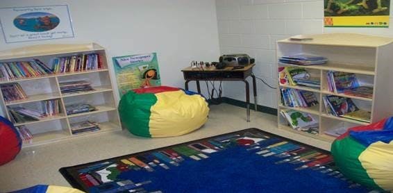 Classroom with bookshelves, beanbag chairs, and a colorful rug
