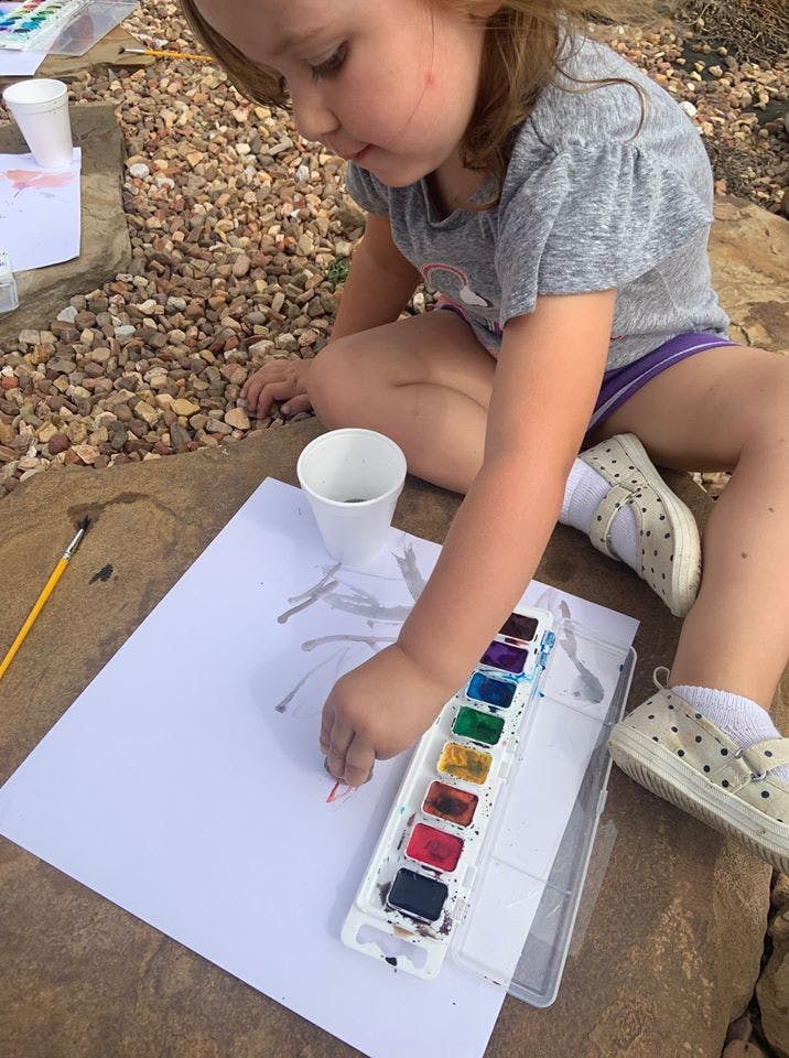 Child painting with watercolors on paper