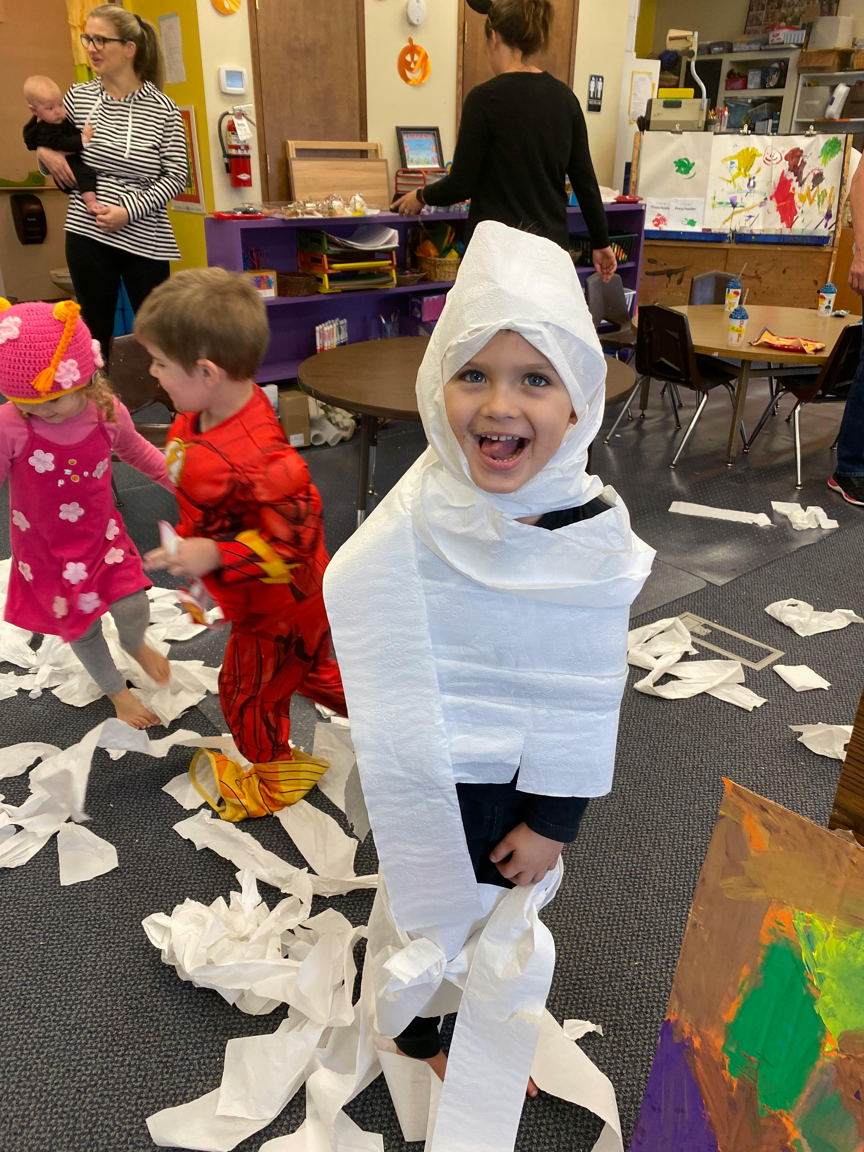 Child dressed as a mummy with toilet paper in a classroom