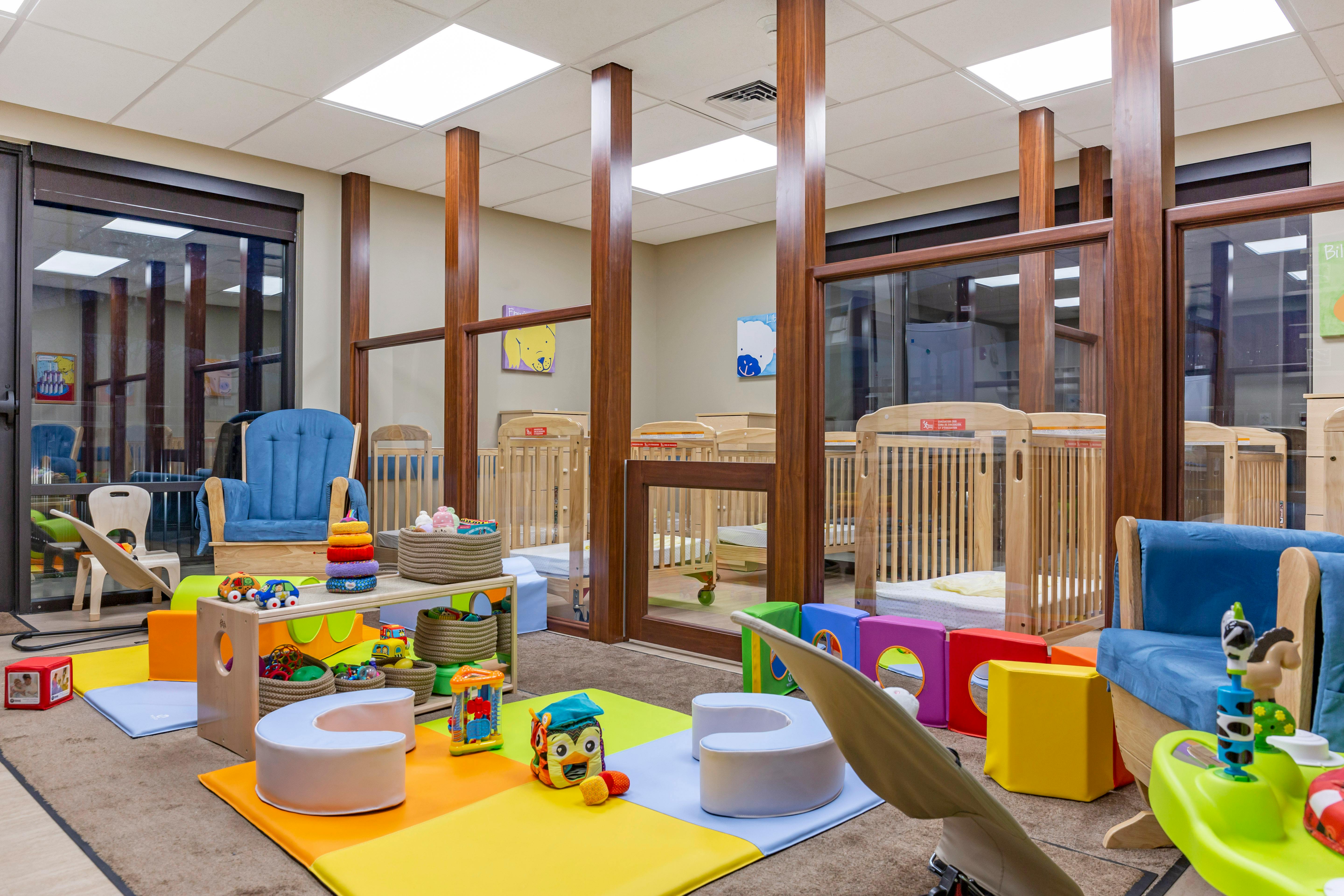 Cribs and colorful toys in a daycare classroom