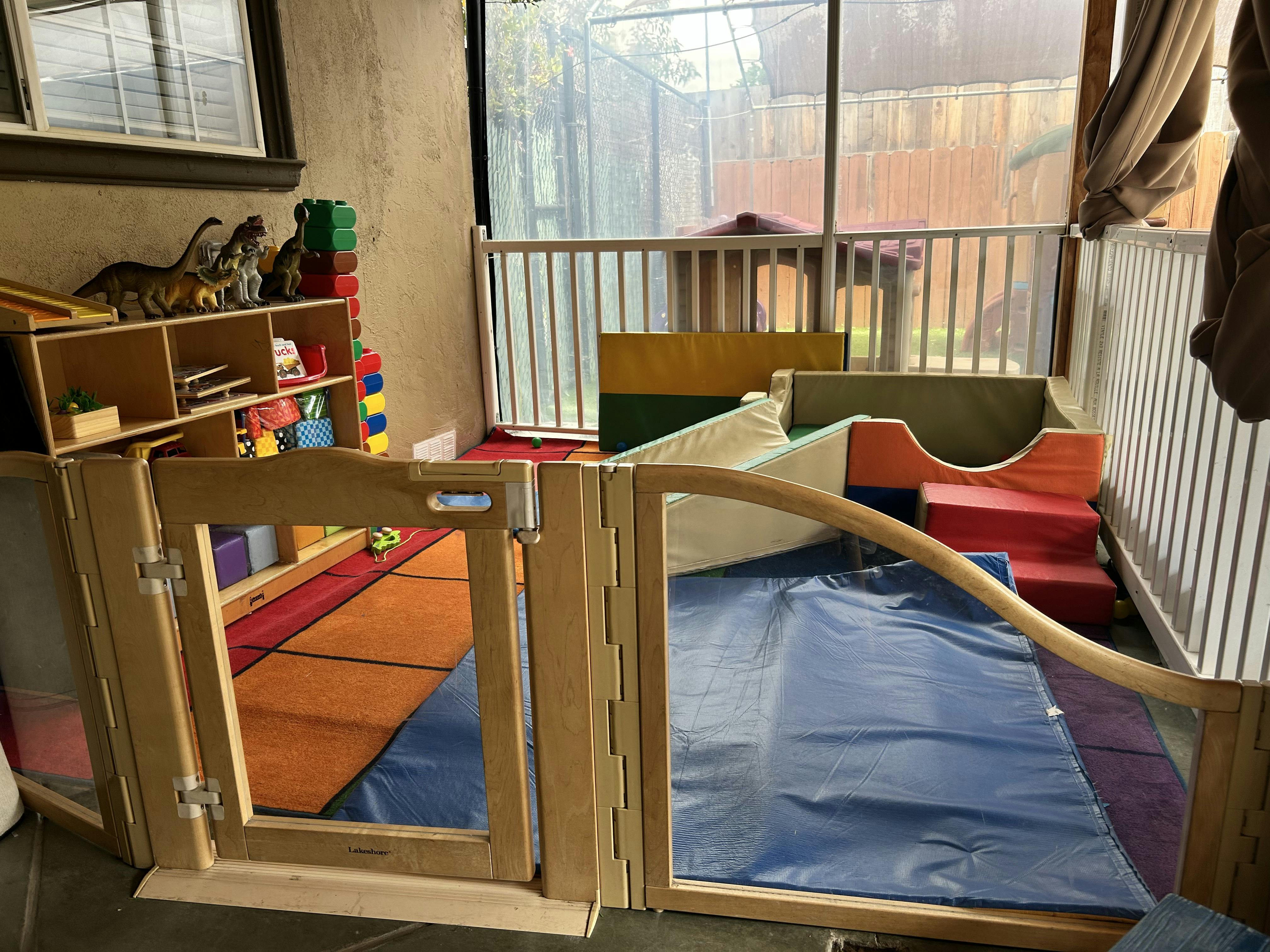 Indoor play area with soft play equipment and a wooden gate