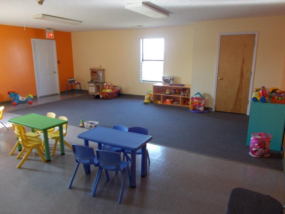 Playroom with small tables and chairs, toys, and a window