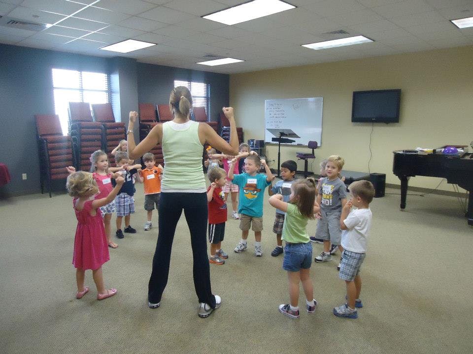 Adult leading a group of children in an exercise class