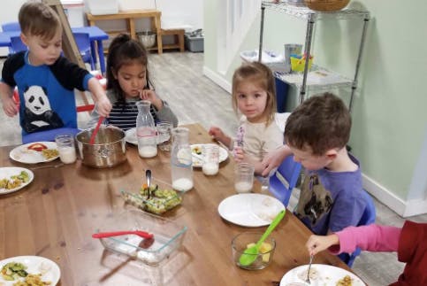 Children sitting at a table with plates and drinks