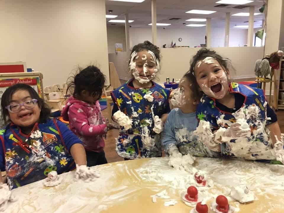 Children playing with shaving cream and flour
