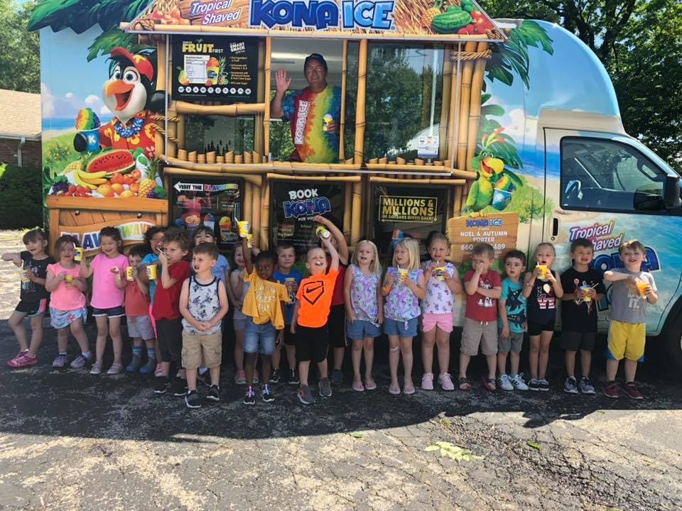 Group of children standing in front of a Kona Ice truck