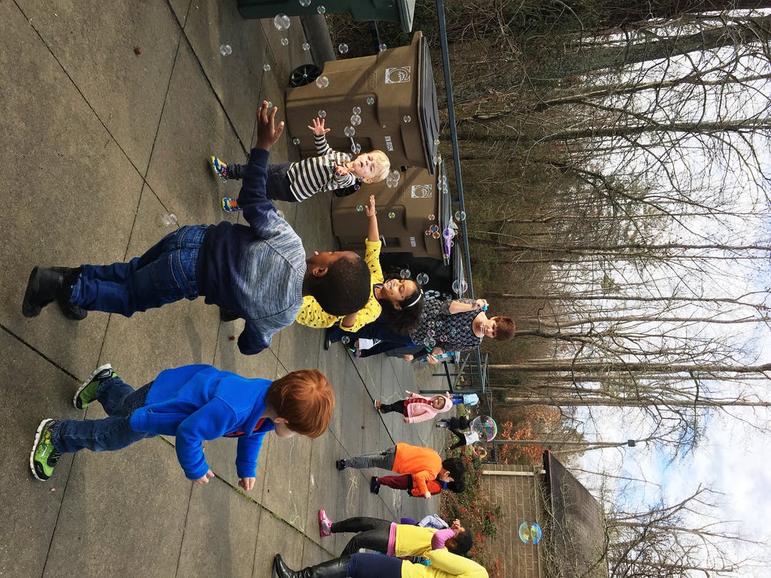 Children playing with bubbles outdoors