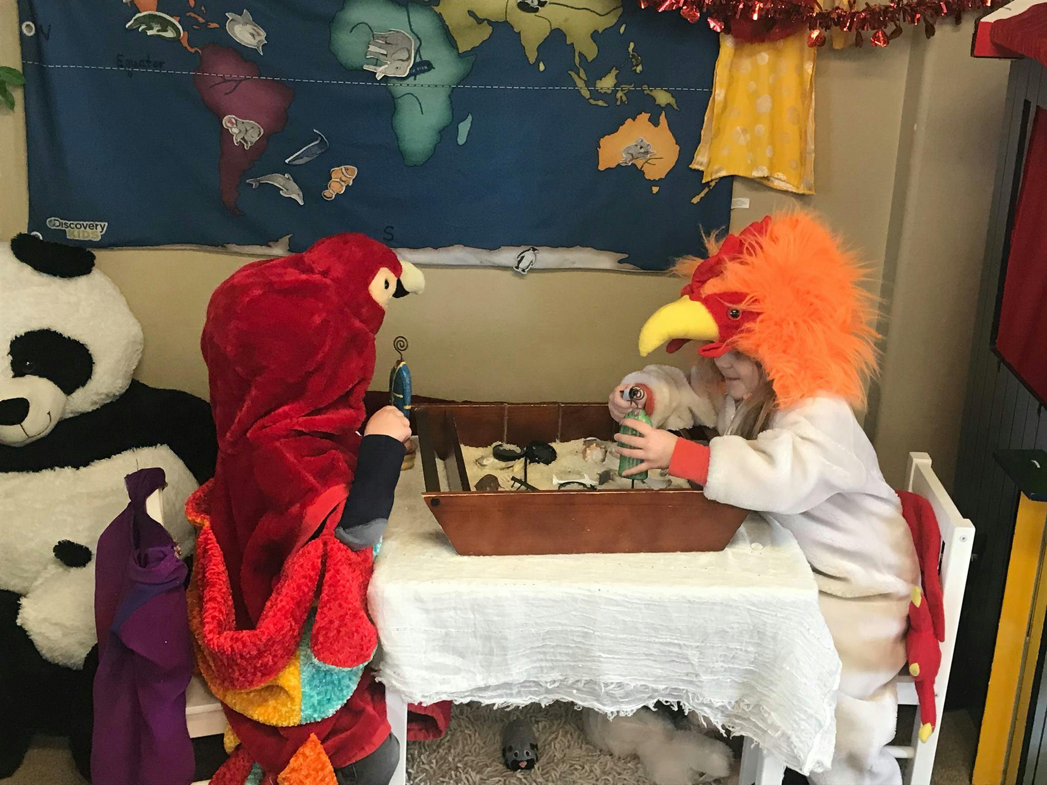 Two children in costumes playing at a table