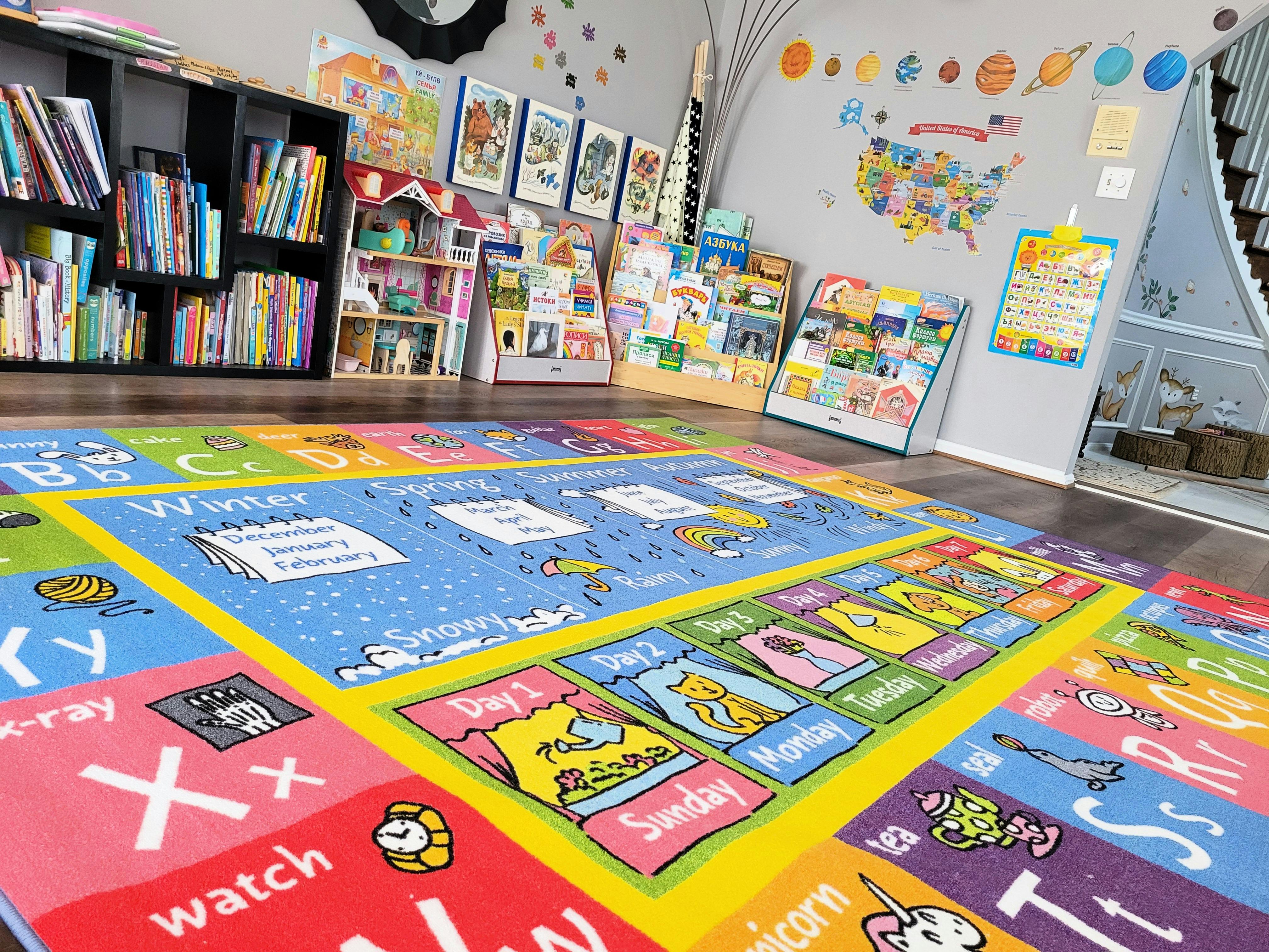 Colorful alphabet and calendar rug in a classroom with bookshelves