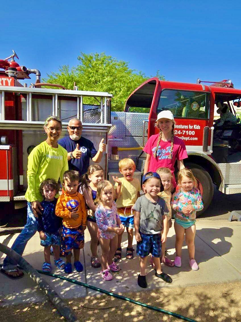 People and children posing in front of a fire truck