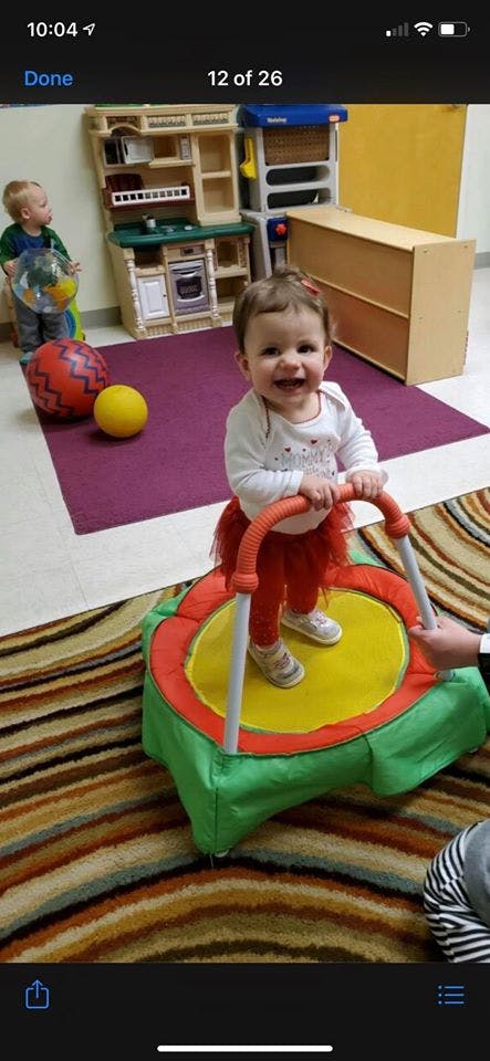 Child standing on a small trampoline with another child in the background
