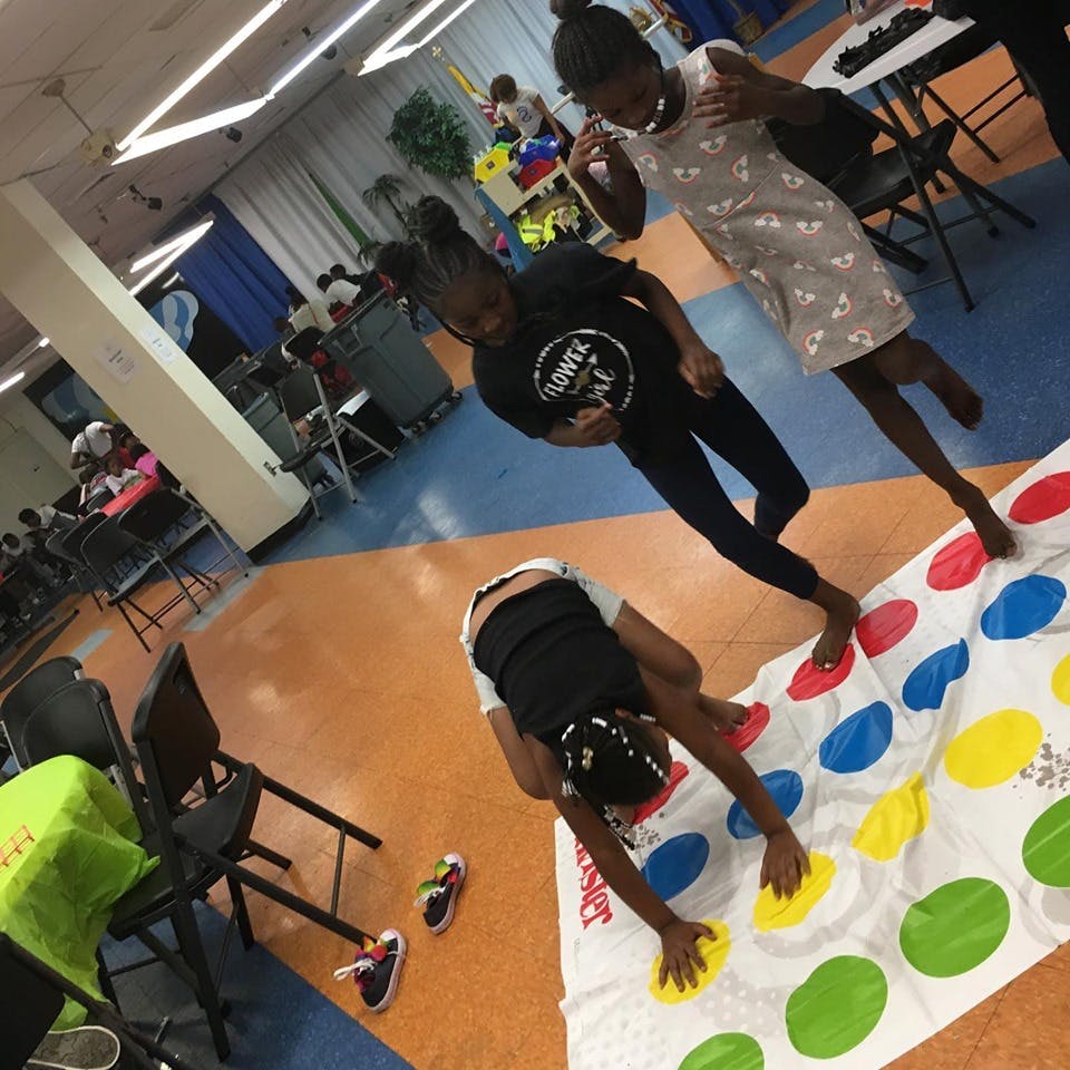Three children playing Twister on a mat