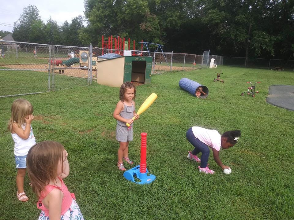 Children playing T-ball on a grassy field