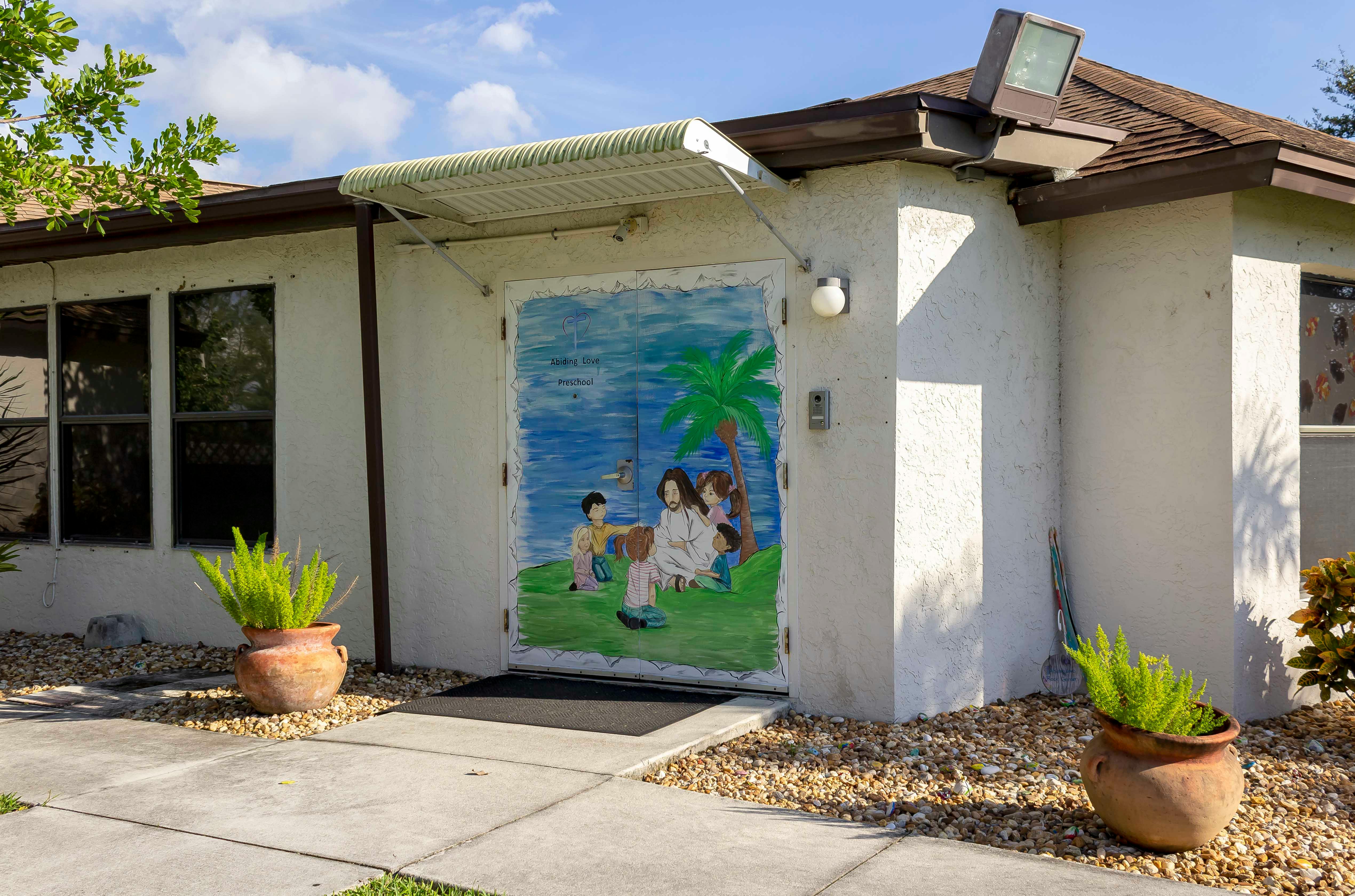 Building exterior with a mural of people and palm trees on a door