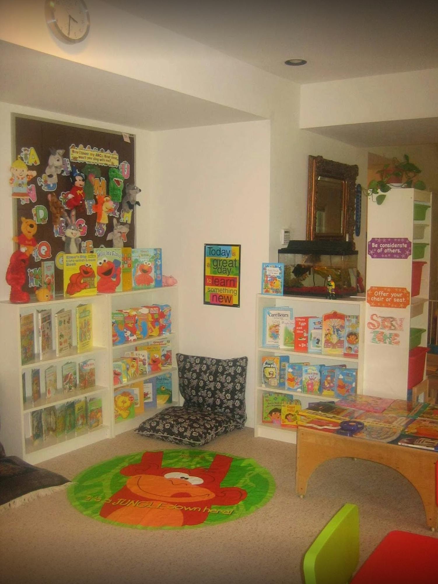 Children's reading nook with bookshelves, floor cushions, and a round rug