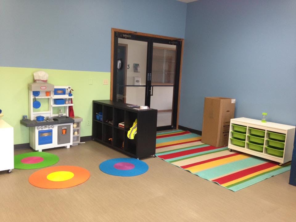 Playroom with toy kitchen, storage units, and colorful rugs