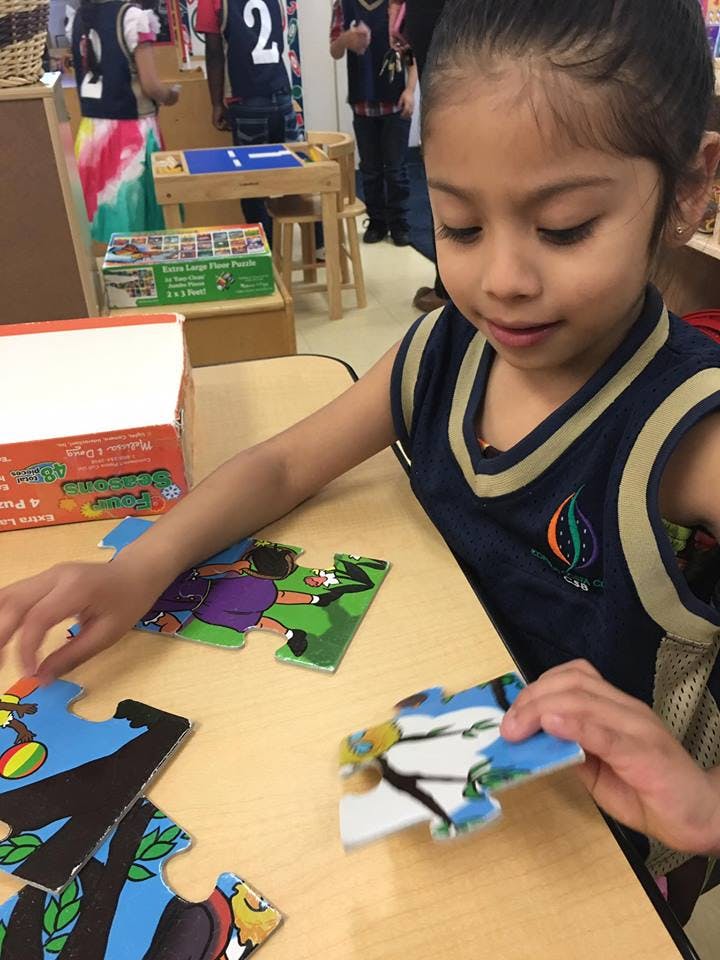 Child playing with a puzzle at a table