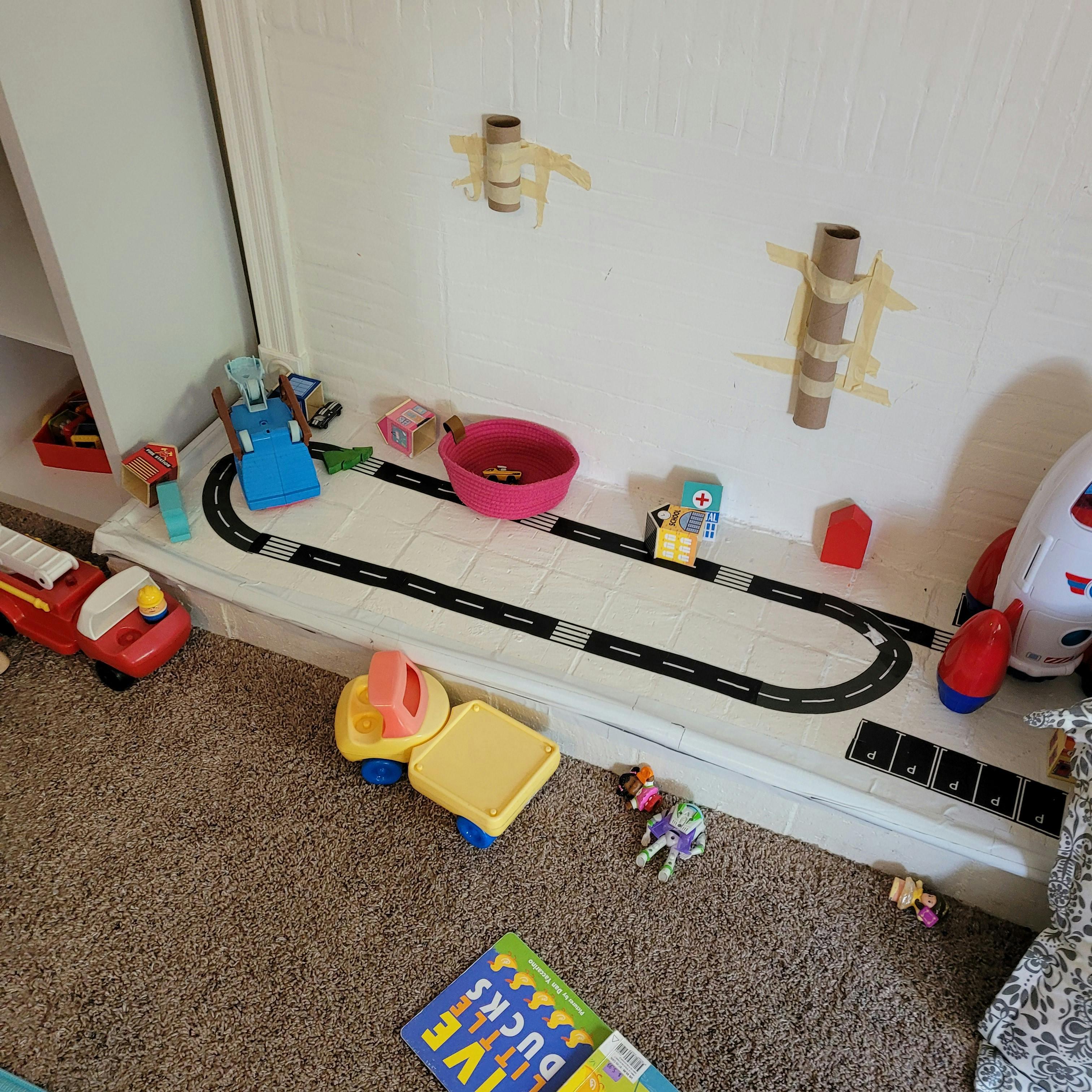 Children's toys on a shelf with a toy road and on the floor