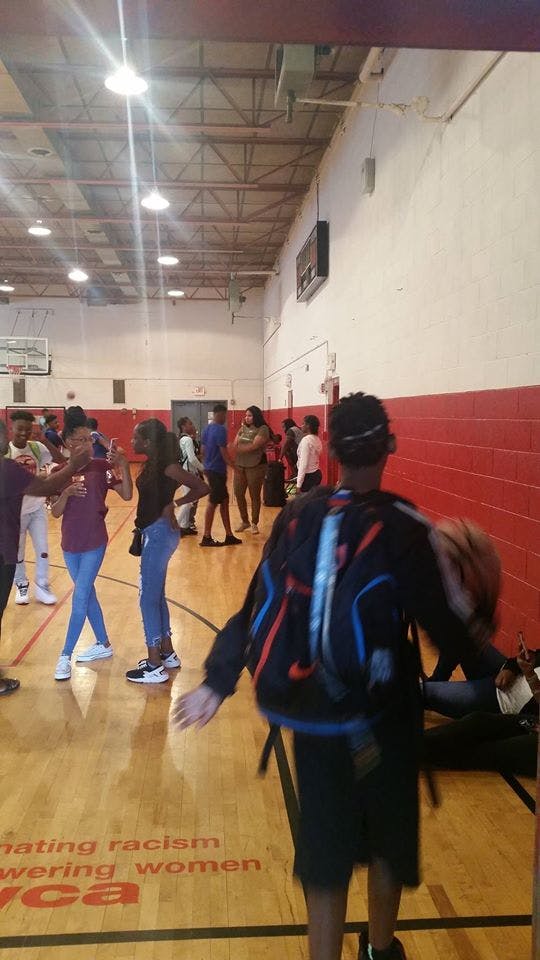 People standing on a basketball court with text on the floor