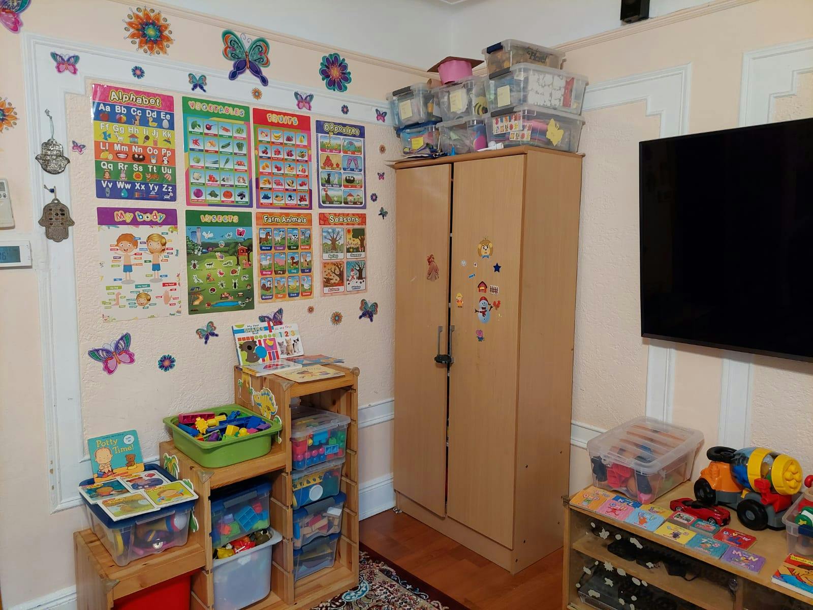 Classroom with educational posters, storage cabinet, and toys