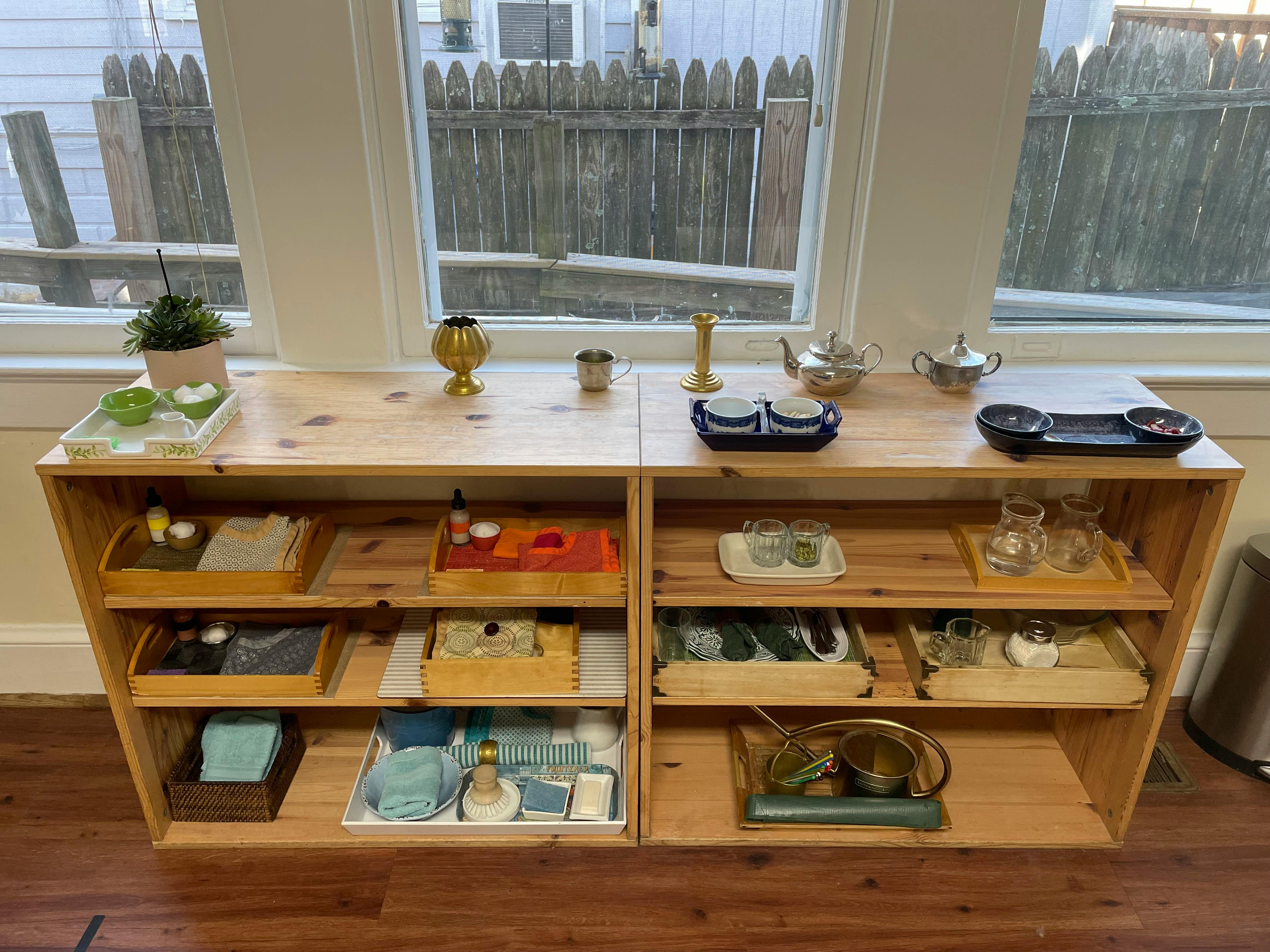 Wooden shelving unit with various items on shelves and top surface