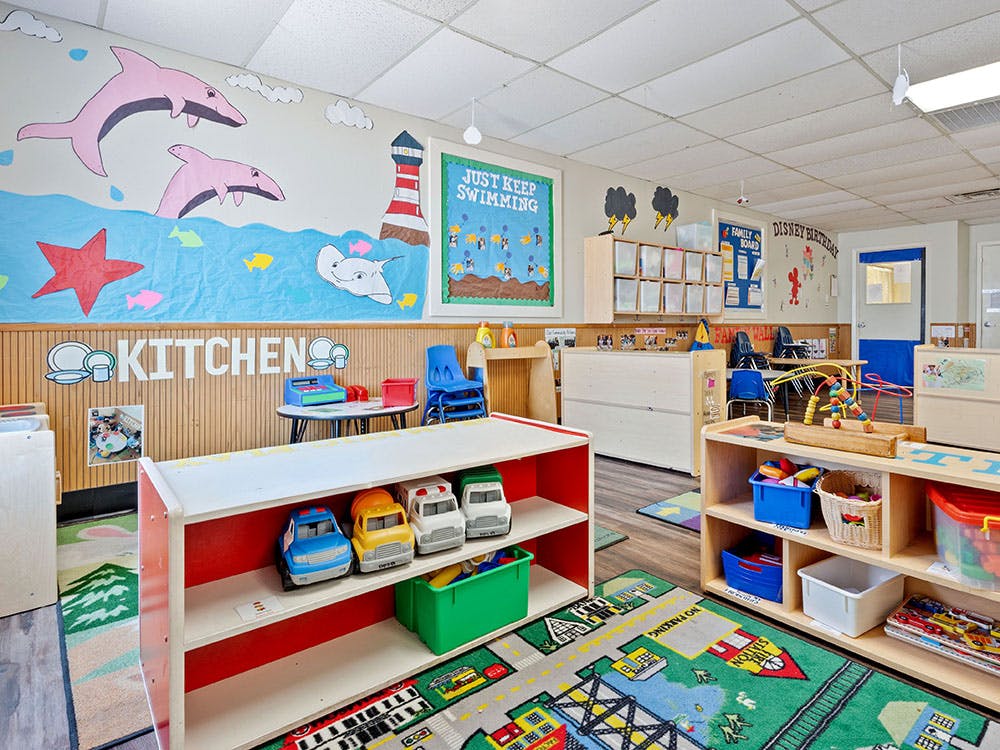 A colorful classroom with play kitchen and marine-themed decorations