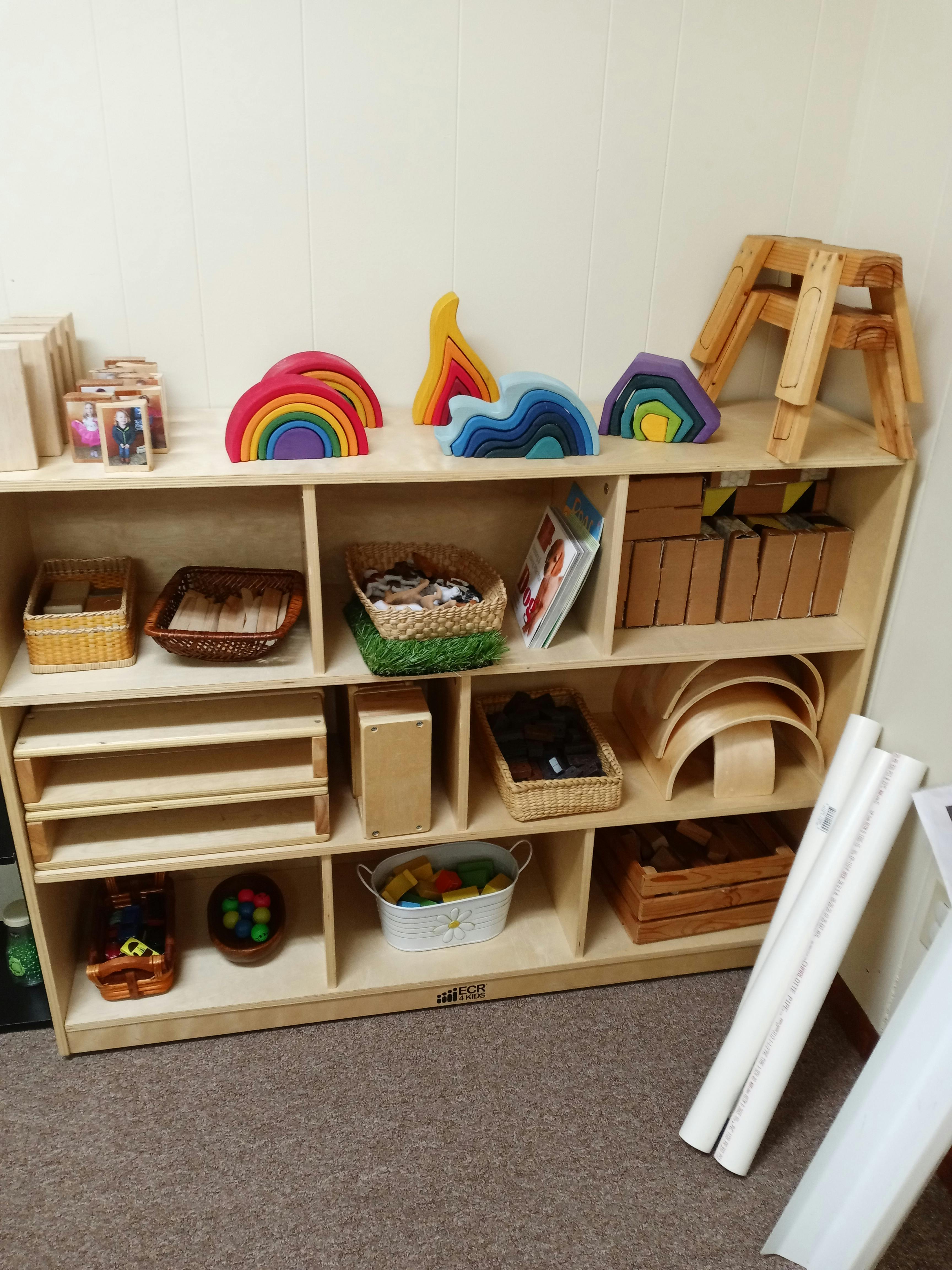 Wooden shelving unit with various toys and baskets