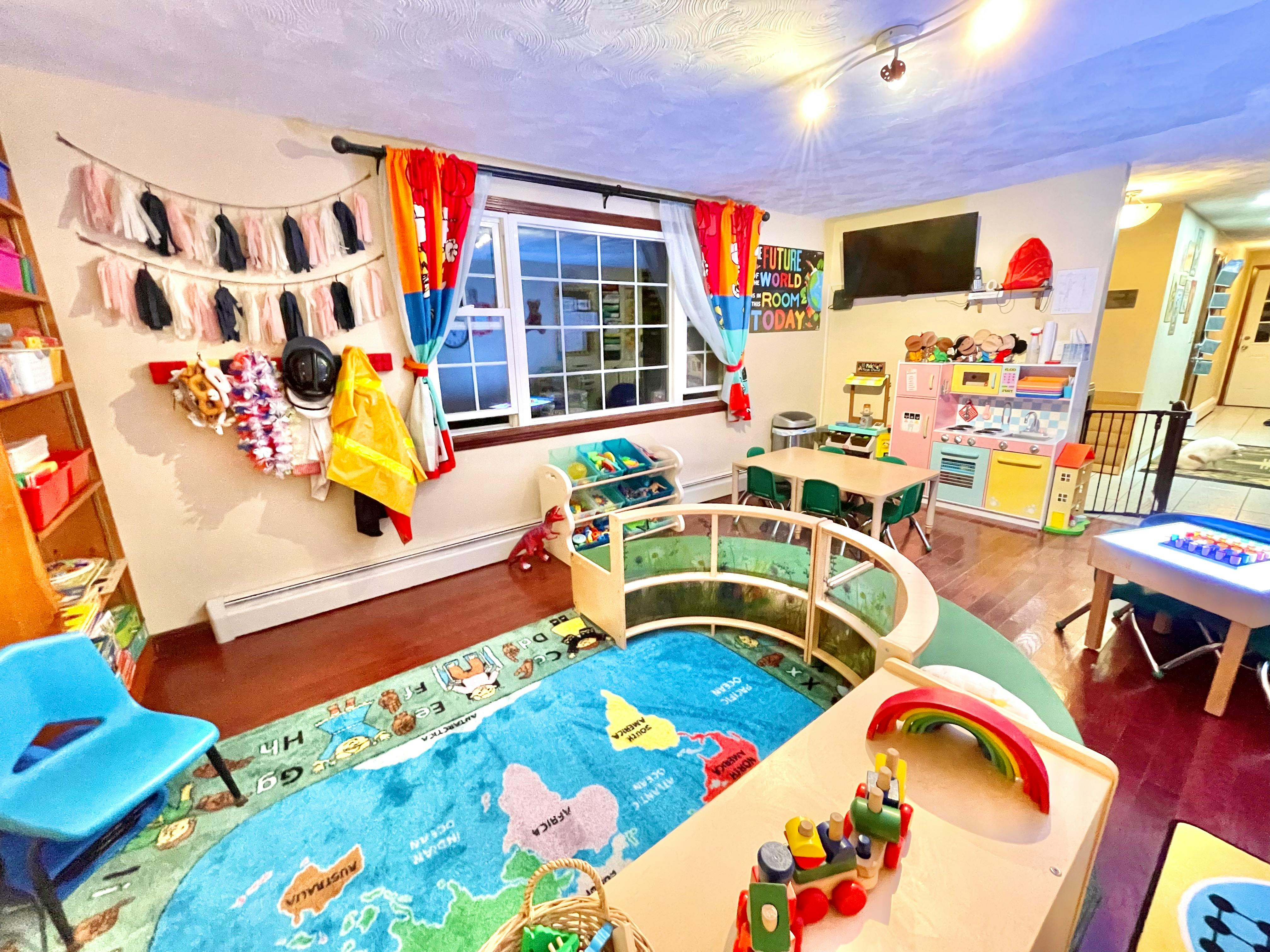Playroom with a world map rug, small tables and chairs, and toys